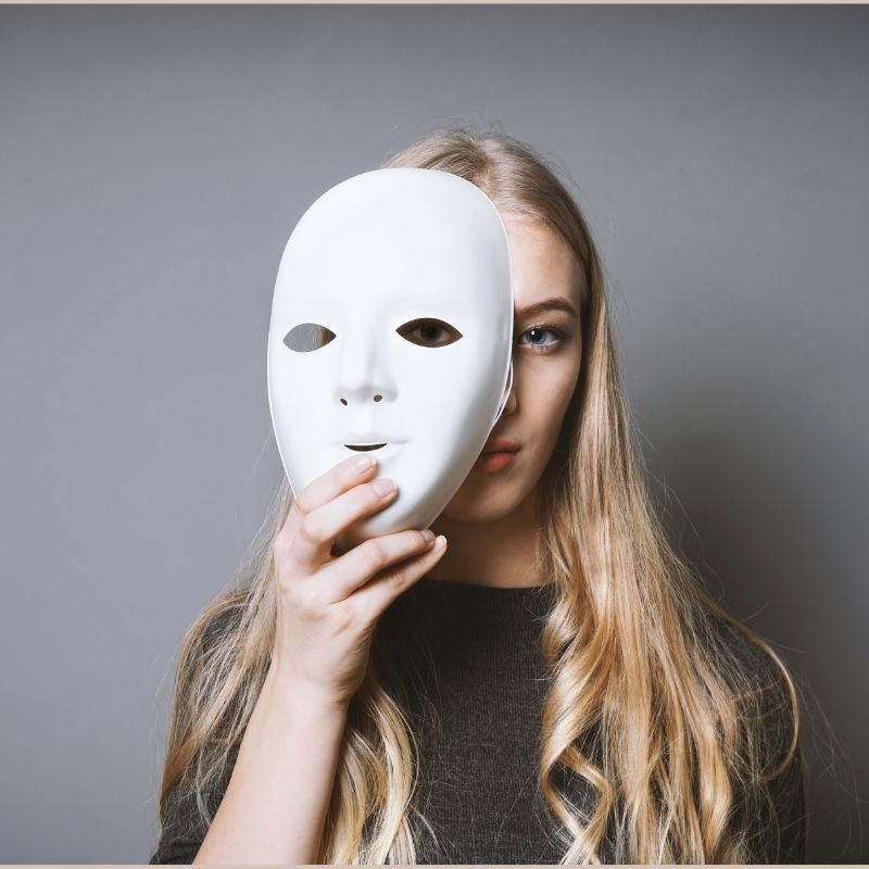 Terapia Cognitivo Comportamental para Transtorno Bipolar 2 mulher segurando uma mascara com transtorno bipolar