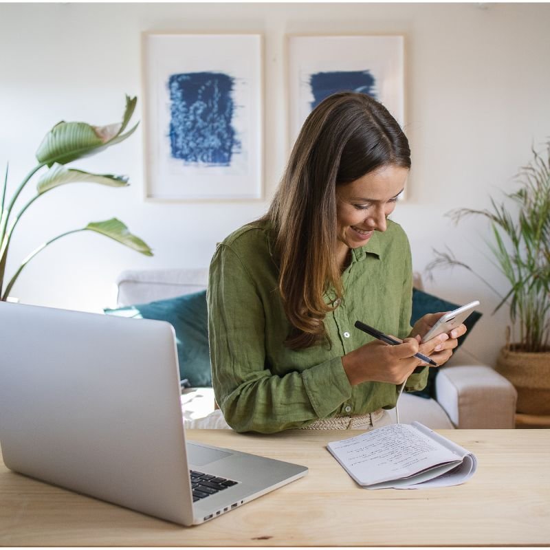 mulher sentada manuseando celular com procrastinação